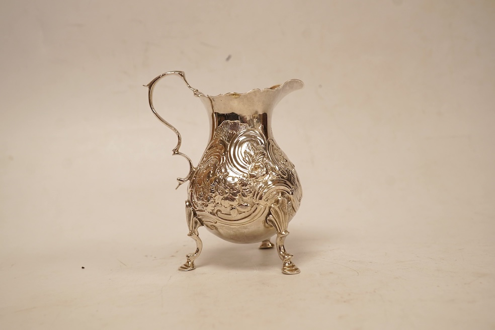 A late George II silver baluster cream jug, with later embossed decoration, on three hoof feet, Samuel Meriton I London, 1756, 10.6cm, 3.3oz.